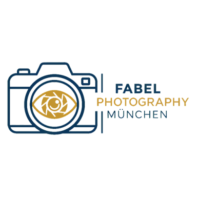 Logo von Fabel Photography München zeigt symbolisch einen Fotoapparat mit einem Auge im Objektiv, neben dem Schriftzug "Fabel Photography München"